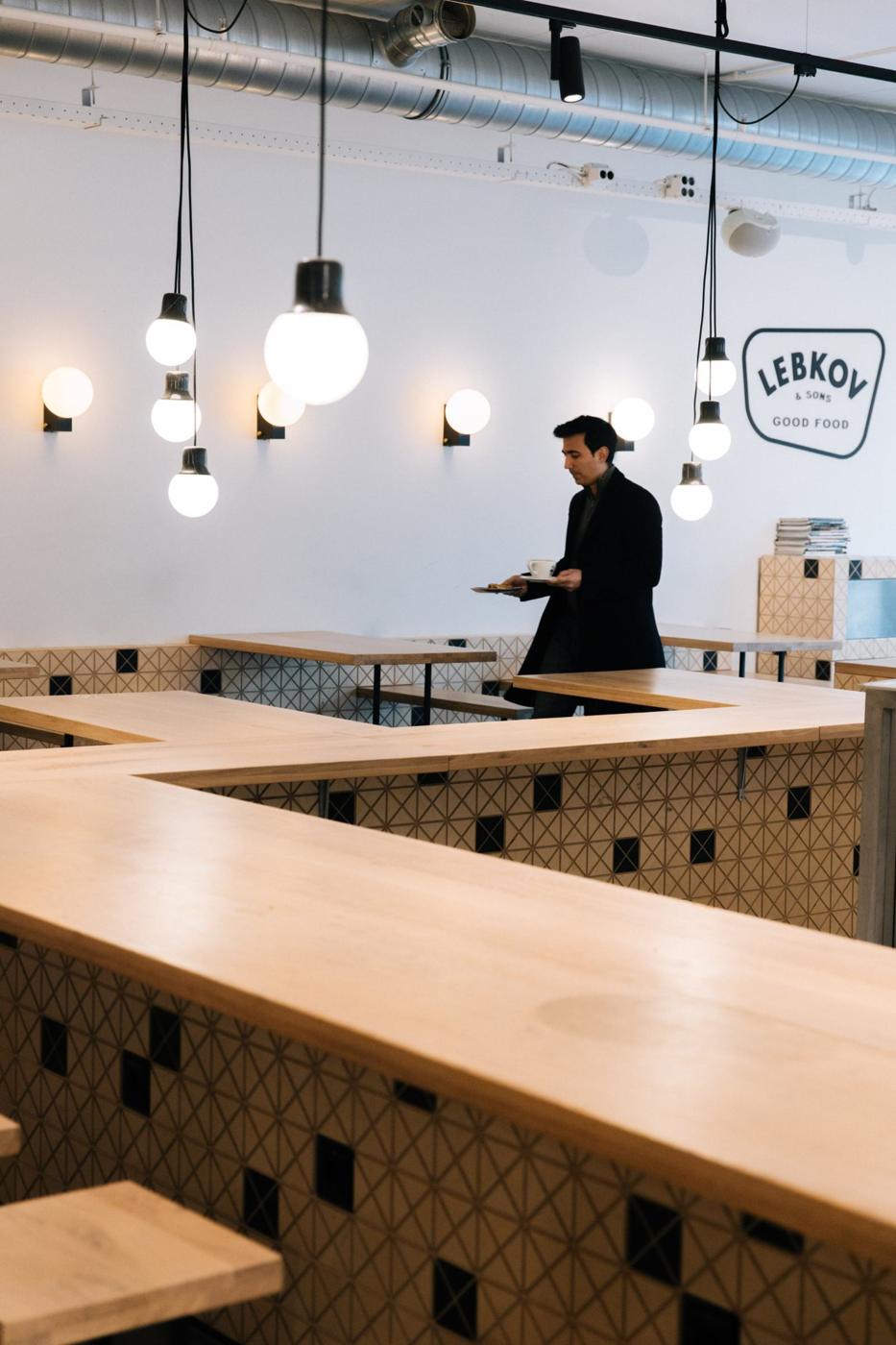 A guest carrying coffee through a Lebkov shop