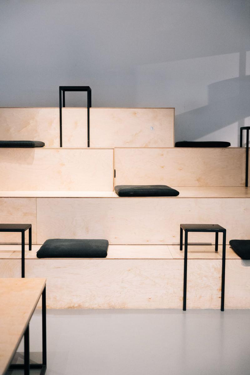 Plywood tiered seating with black cushions