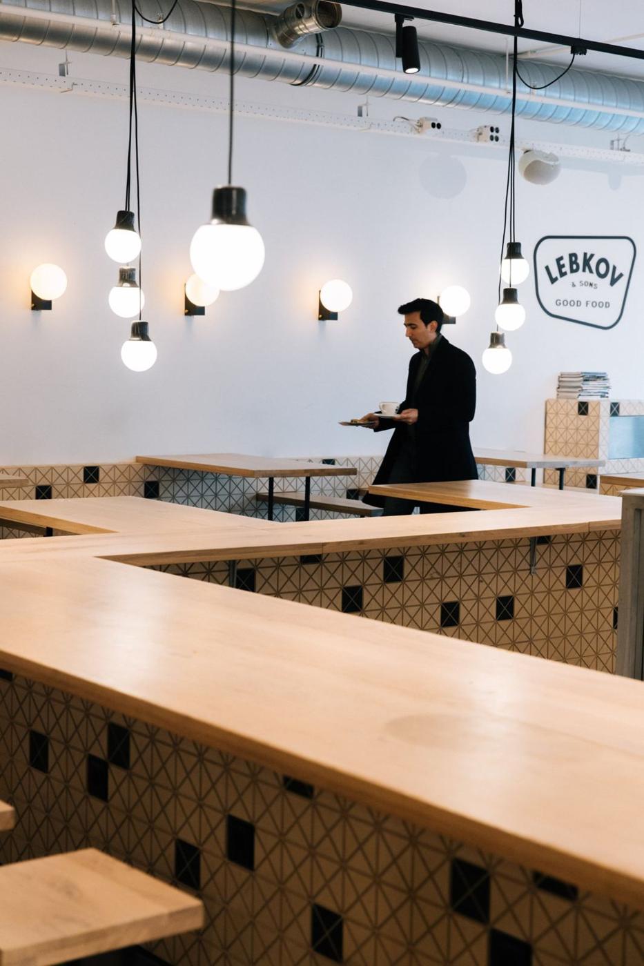 A guest carrying coffee and a pastry through Lebkov