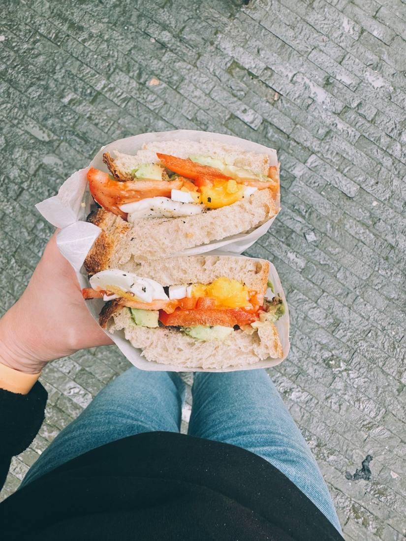 A sandwich with avocado, egg and tomato on sourdough