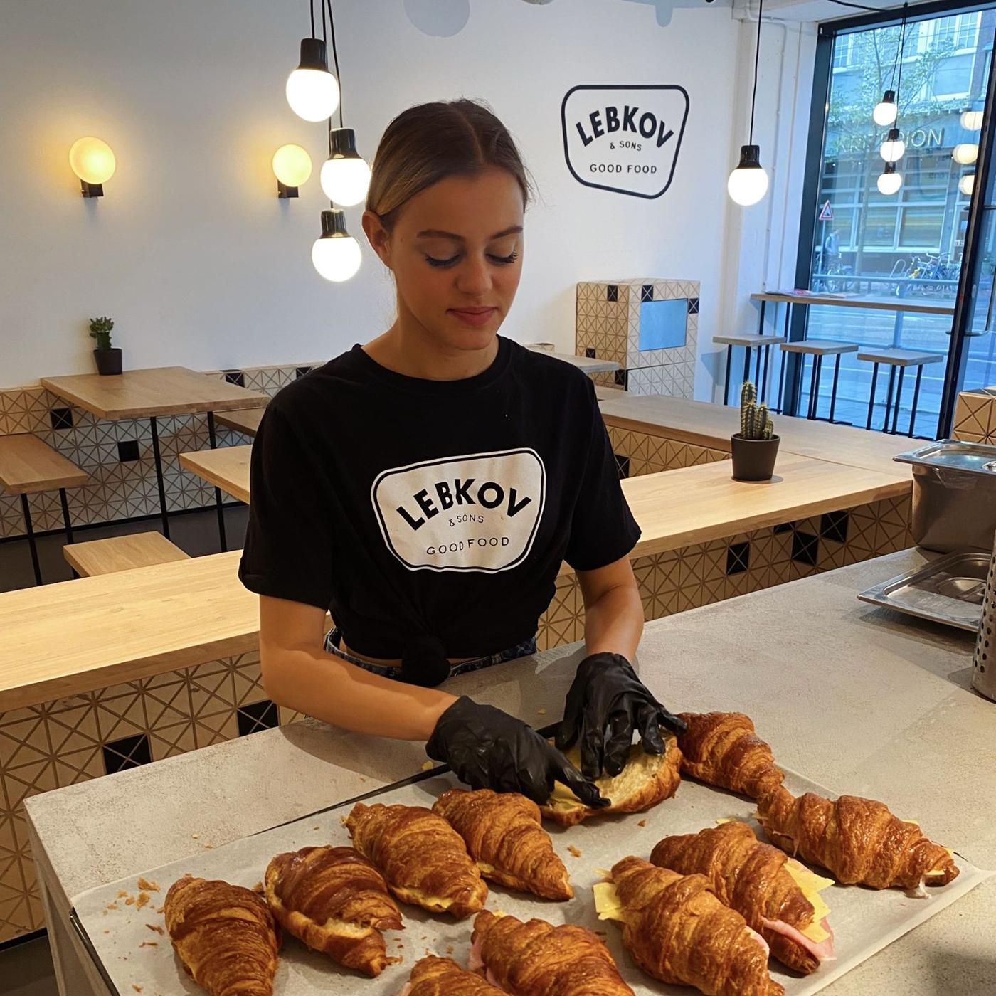 A Lebkov team member filling croissants